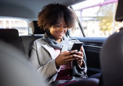 Woman sitting in the back of a cab, enjoying Local Taxi Service in Peoria IL