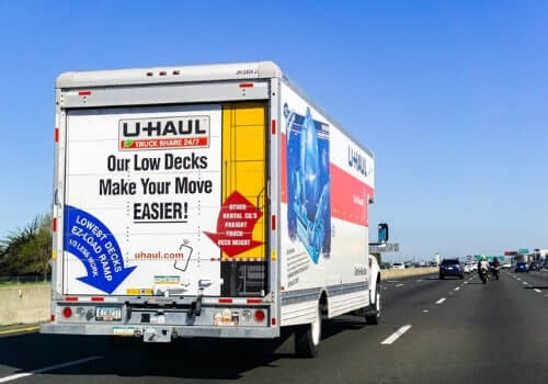 A U-Haul truck is being driven down the road. This is one of the services you can call from Curt's Transportation Services, in addition to "Cab Service Near Me"