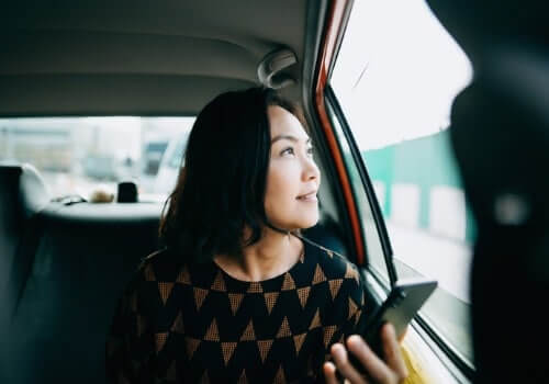 A woman looking at the window of Local Cabs in Peoria IL