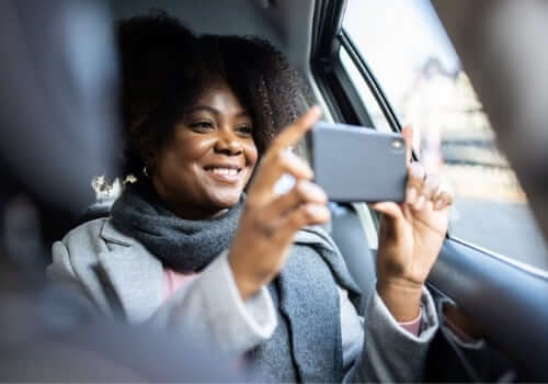 A woman takes photos out of the back of her cab after calling for Airport Transportation from East Peoria IL