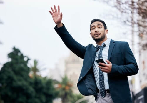 A business man waves for Taxi Service in Morton IL after calling Curt's Transportation Services