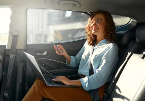 A woman works in the back of a taxi. If you're wondering "Are Taxis Safe?", Curt's Transportation Services offers the safest, smoothest ride in the Peoria area.